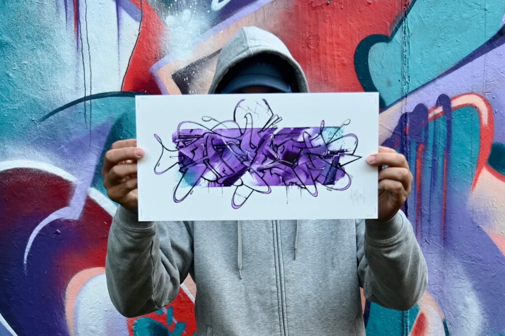 Theron holding a print Purple Paint