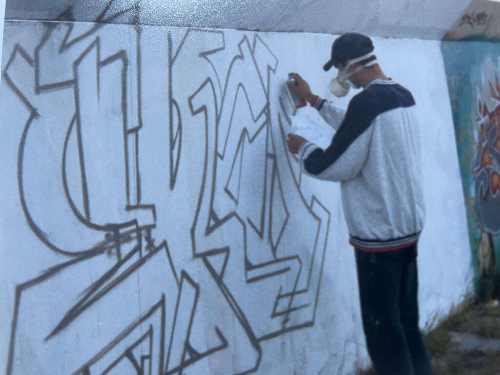 Theron at work sketching his graffiti piece 